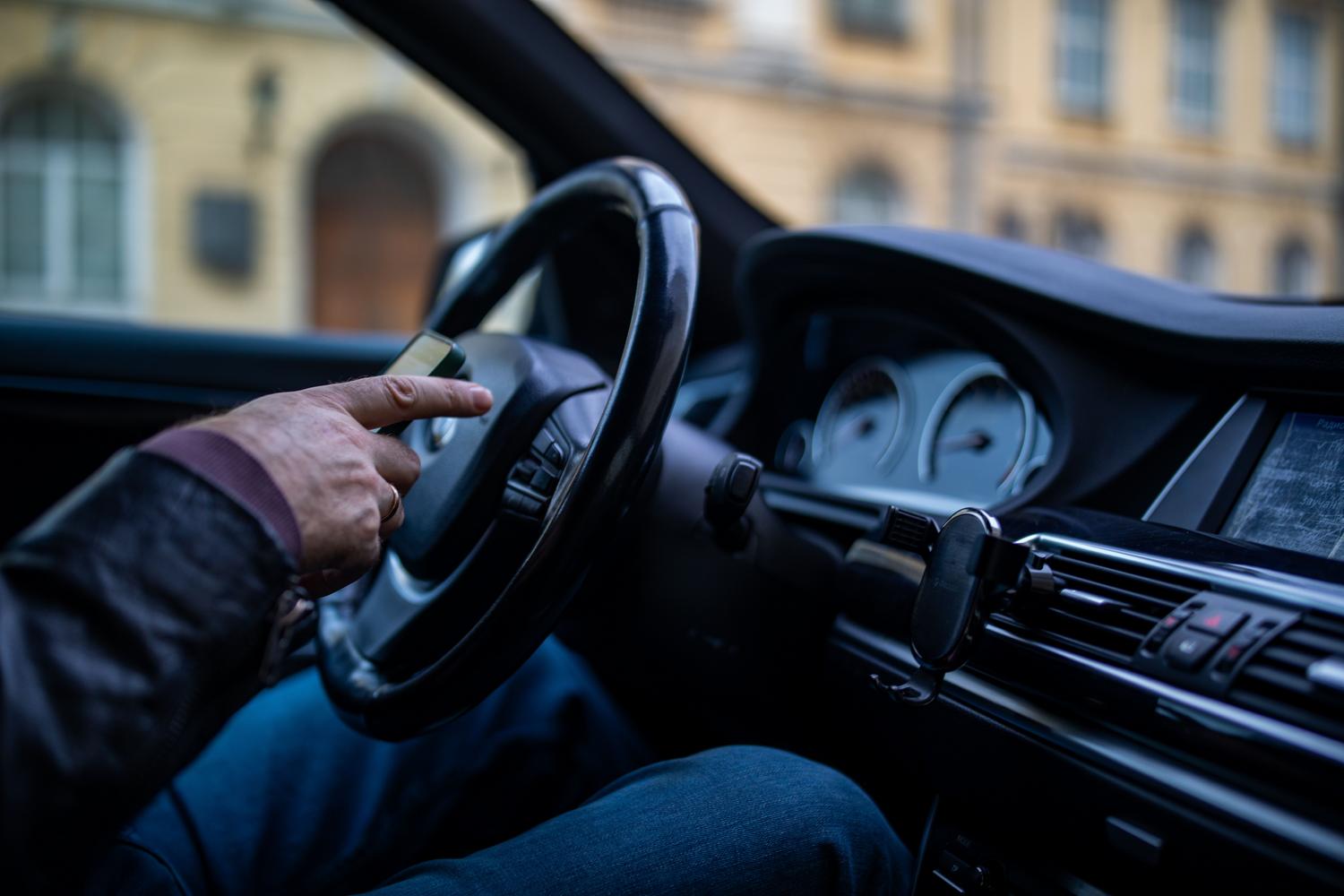 Persona utilizando un smartphone en el interior de un coche moderno