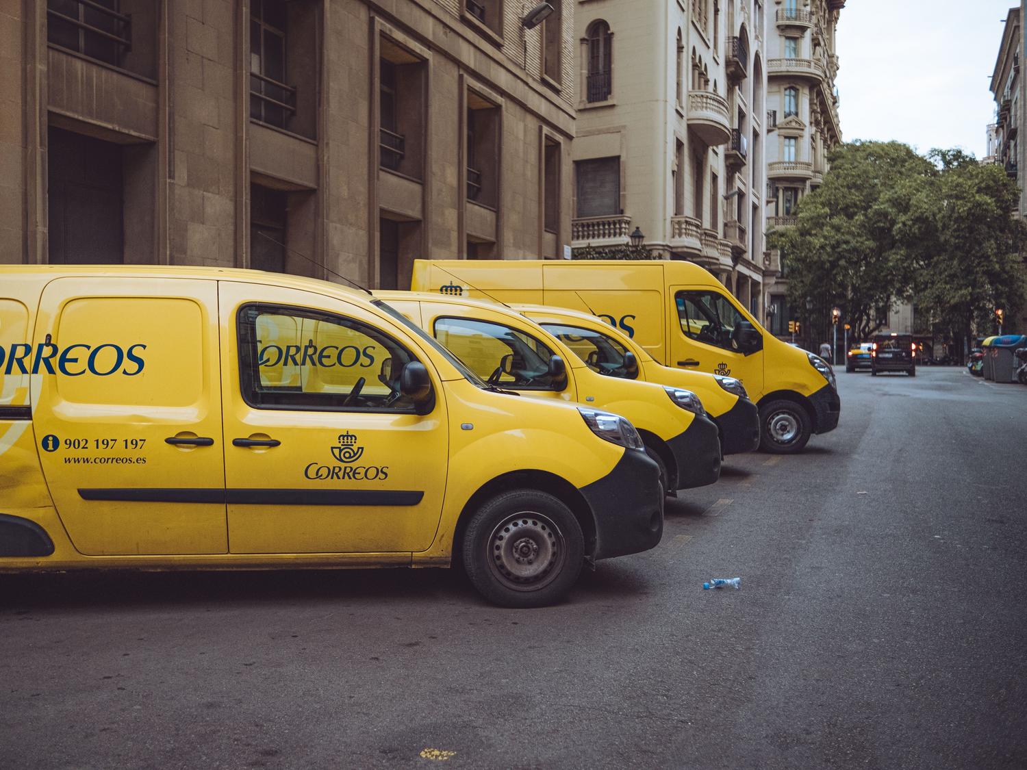 Furgonetas de reparto urbanas estacionadas, ejemplificando la gestión de la última milla y la eficiencia en el transporte urbano.