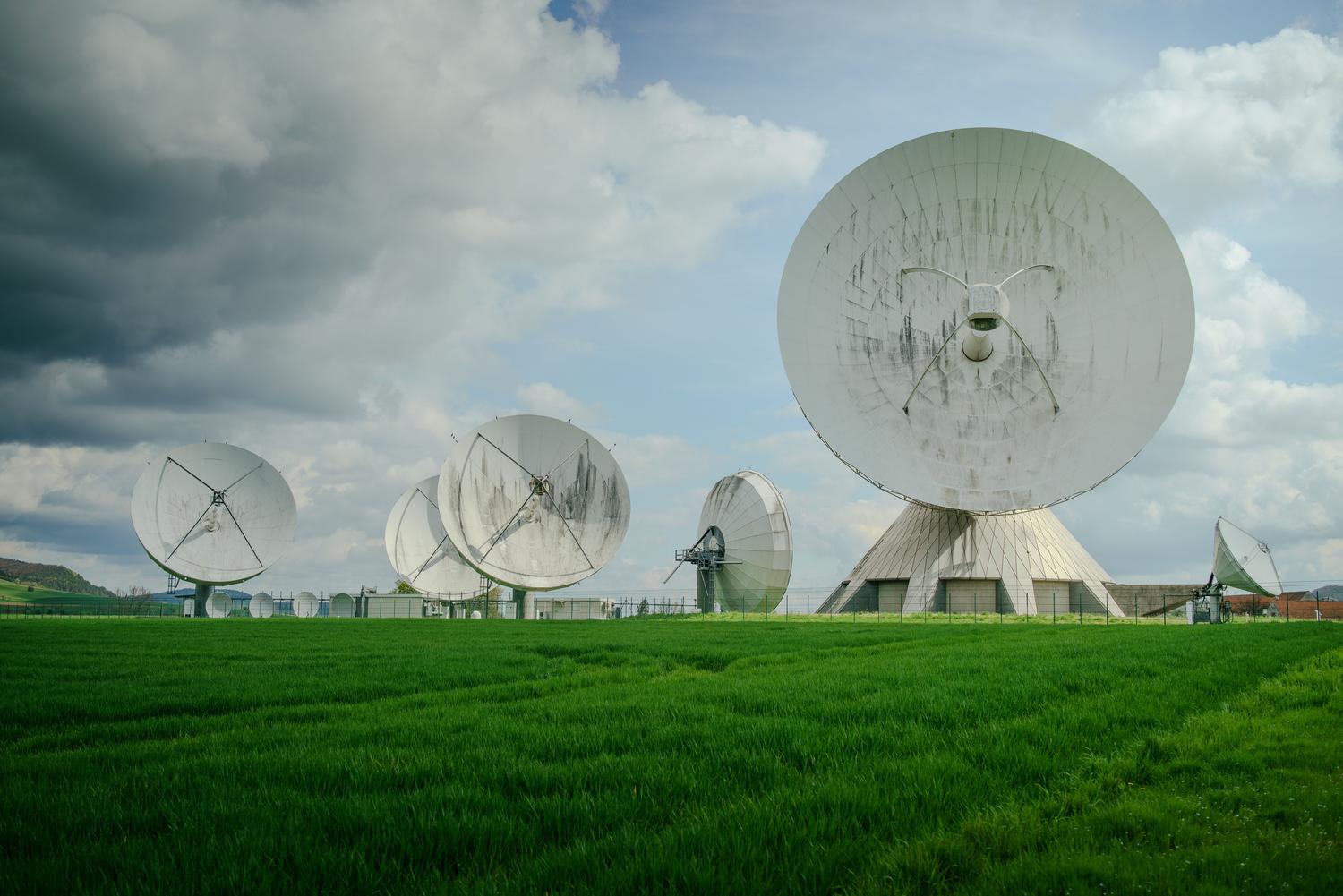 Estaciones de control terrestre con antenas parabólicas utilizadas para la sincronización y vigilancia de los satélites en el espacio.