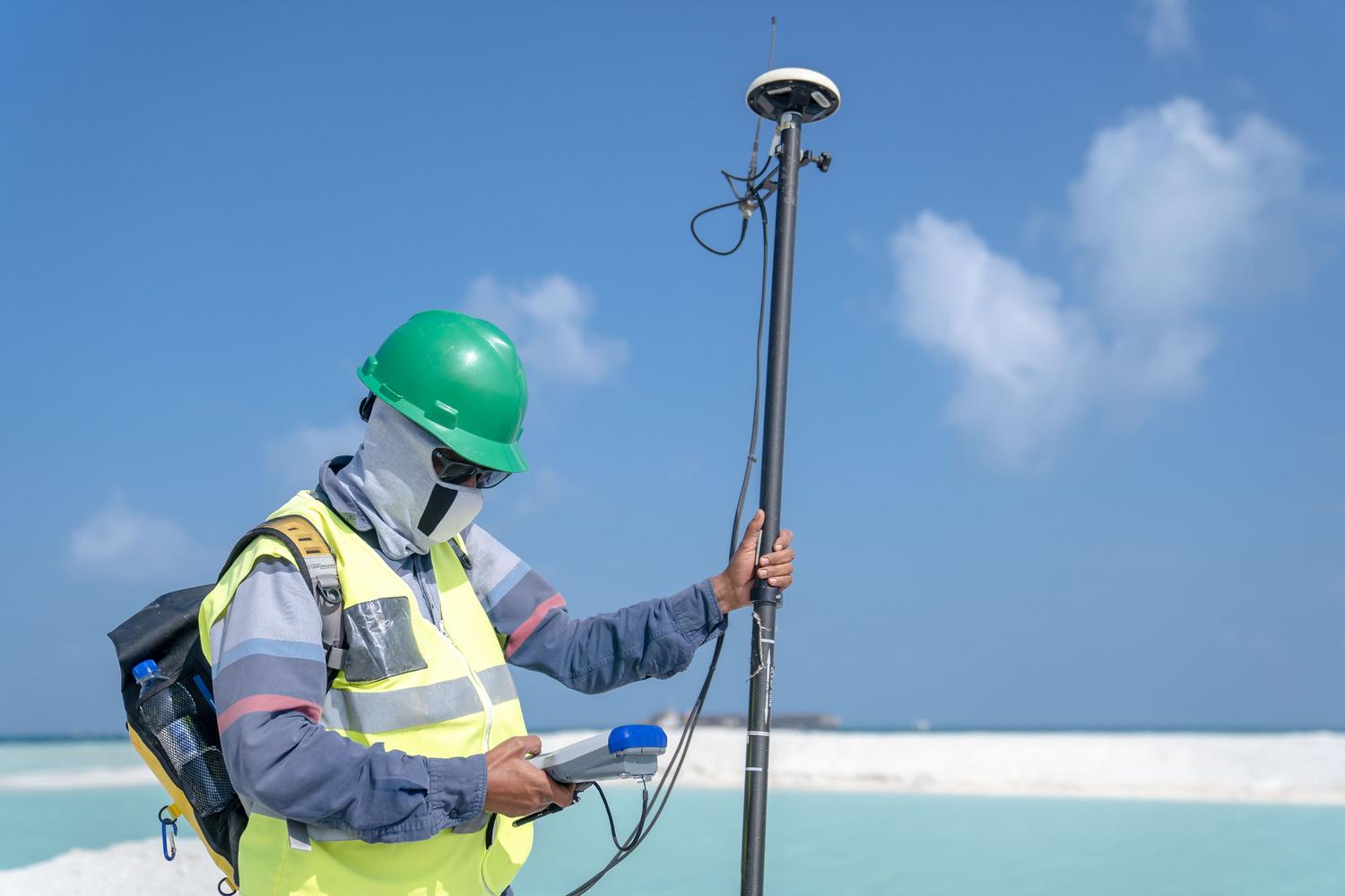 Especialista utilizando equipo de posicionamiento global de alta precisión para trabajos de topografía y agricultura de precisión.