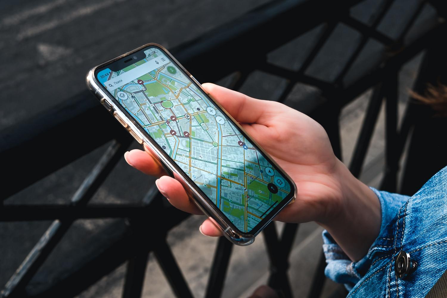 Primer plano de una persona utilizando una aplicación de mapas en su teléfono móvil, representando la democratización del acceso al GNSS.