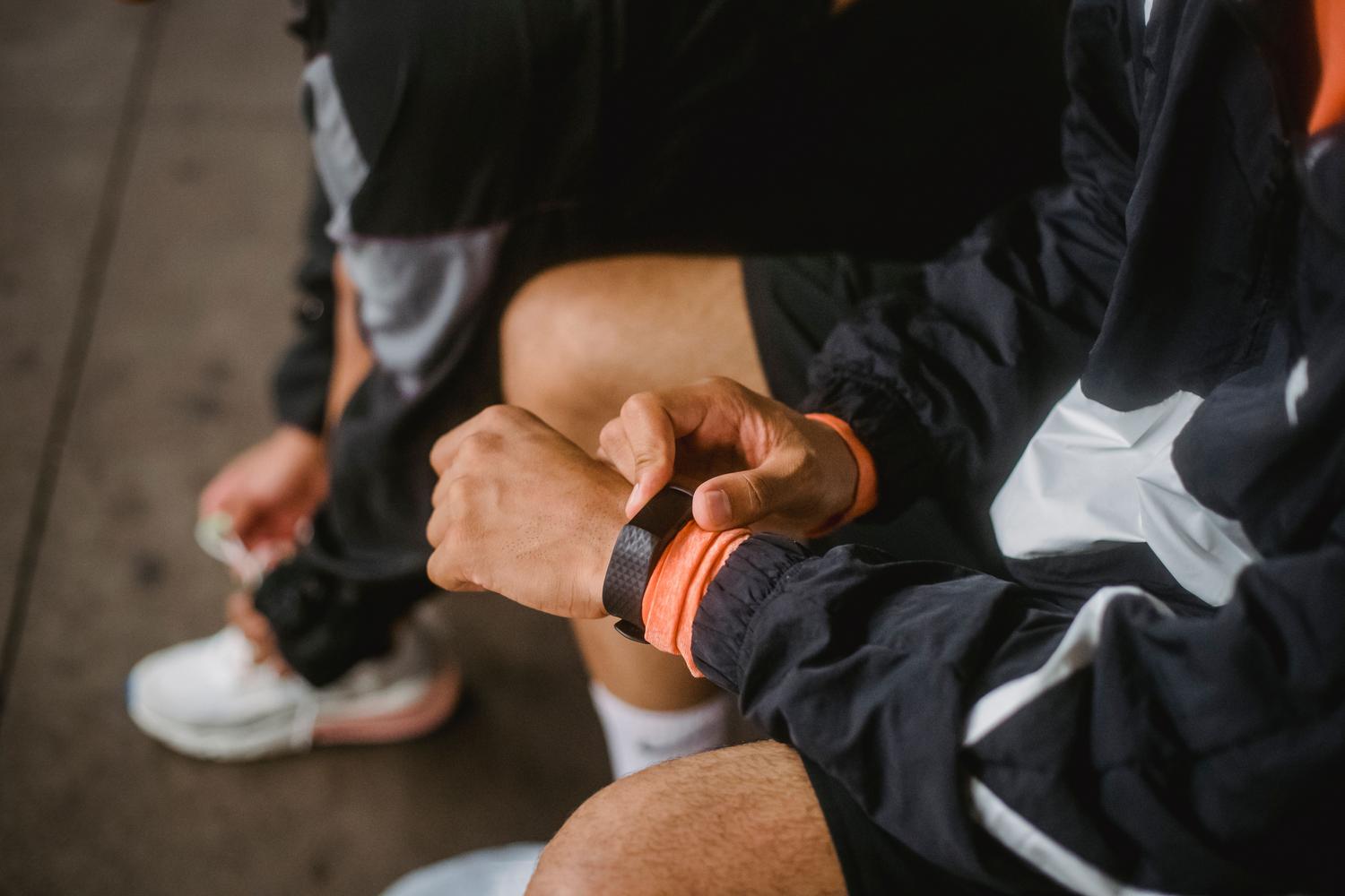 Hombre ajustando la configuración de su smartwatch antes de comenzar su rutina de ejercicio