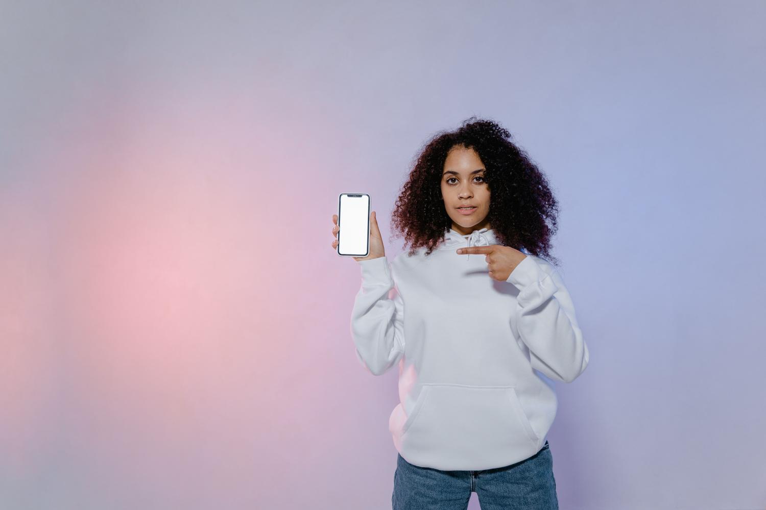 Persona señalando la pantalla de un móvil, representando la acción de mostrar el código QR de la app miDGT