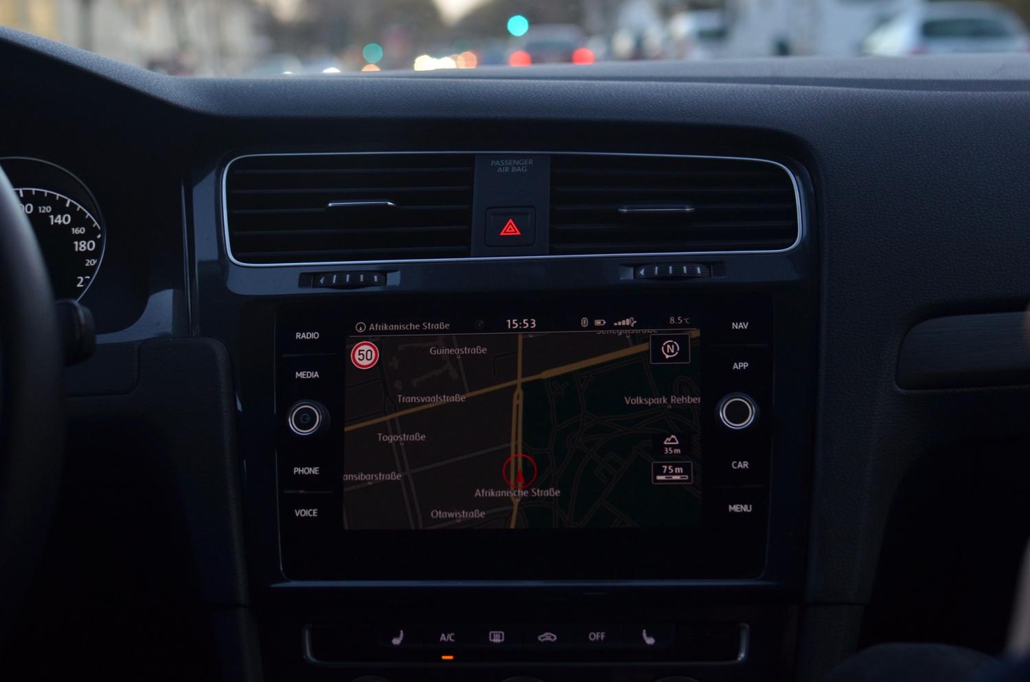 Vista del salpicadero de un coche con ruta de navegación inteligente trazada a través de calles urbanas
