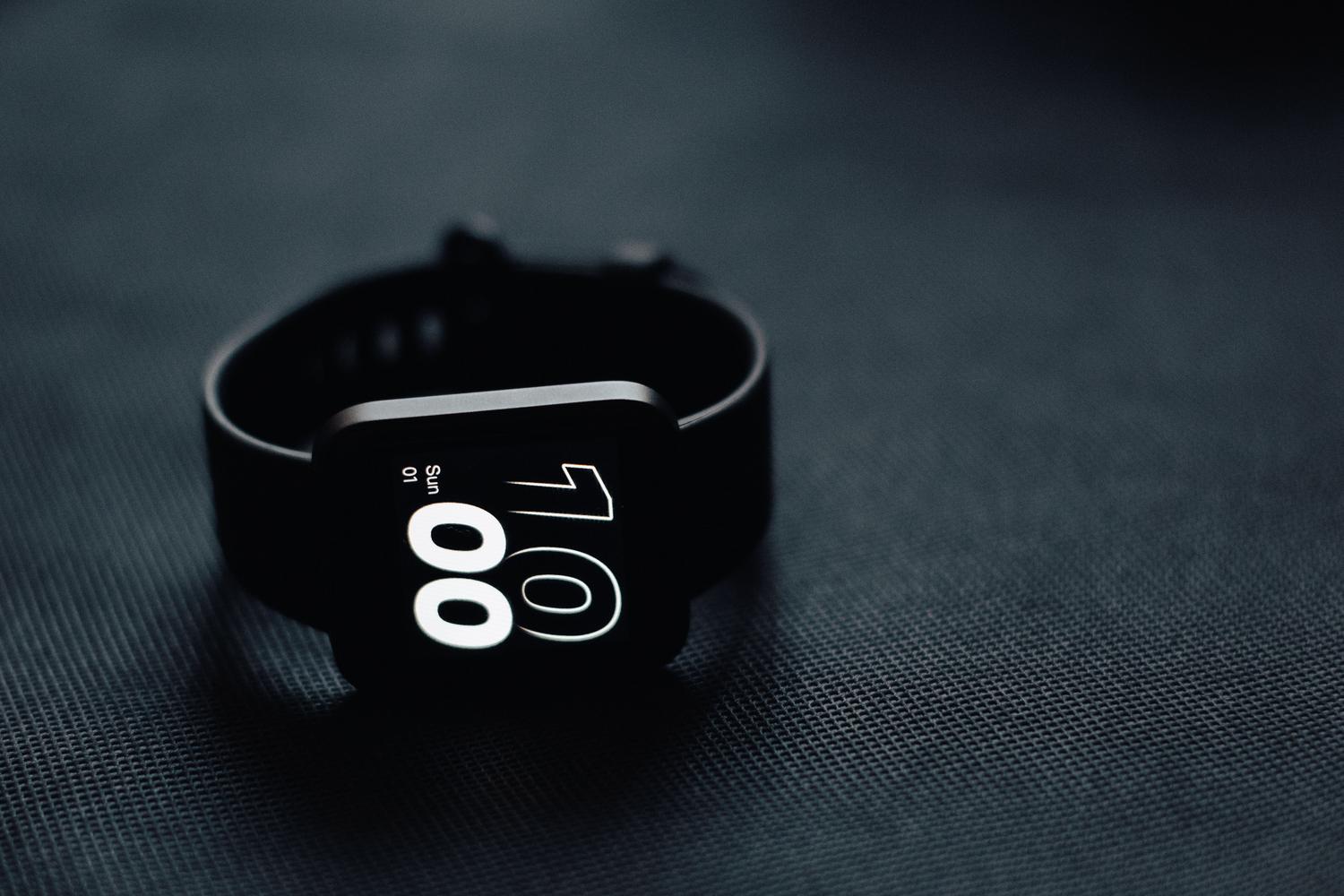 Primer plano de un smartwatch moderno con pantalla AMOLED destacando el contraste y los negros profundos.