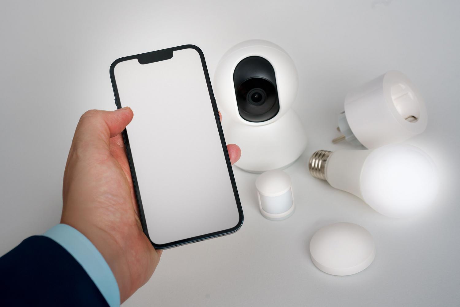 Persona utilizando una aplicación de domótica en su smartphone para gestionar la seguridad y las luces del hogar de forma remota.
